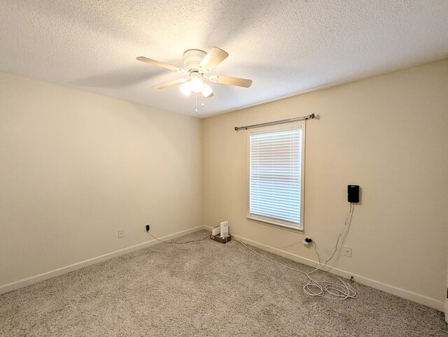 unfurnished room featuring carpet floors, a textured ceiling, baseboards, and a ceiling fan