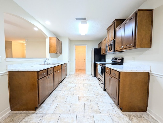 kitchen with light countertops, visible vents, appliances with stainless steel finishes, a sink, and baseboards