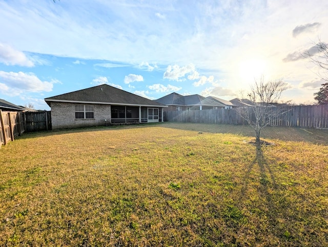 view of yard with a sunroom and a fenced backyard