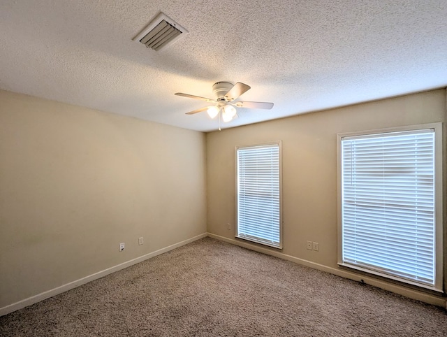 spare room featuring light carpet, baseboards, visible vents, and a ceiling fan