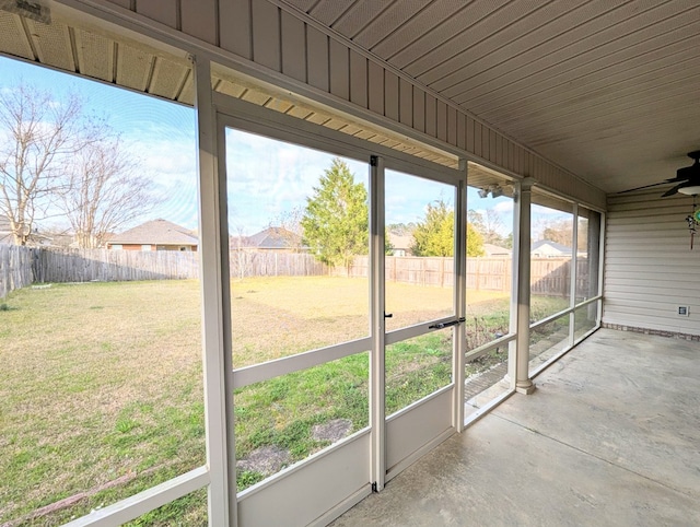 unfurnished sunroom with a ceiling fan