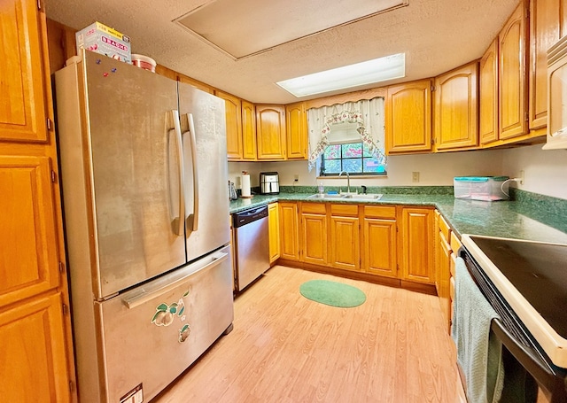4955 County Road 36, Hartford, AL 36344 - kitchen with stainless steel appliances, a sink, light wood-style flooring, a textured ceiling, and brown cabinetry