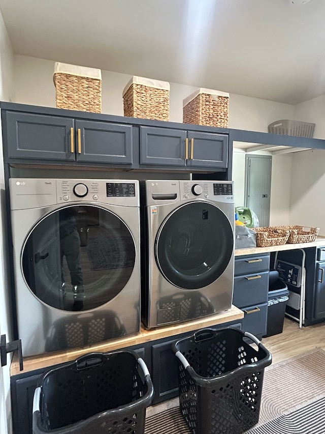 489 Skipper Rd, Malvern, AL 36375 - laundry room with light wood-type flooring, cabinet space, and washer and dryer
