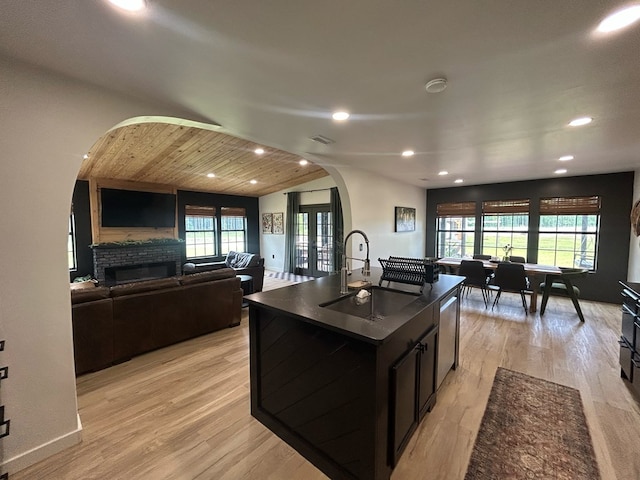 489 Skipper Rd, Malvern, AL 36375 - kitchen with a sink, a glass covered fireplace, dark countertops, recessed lighting, and arched walkways