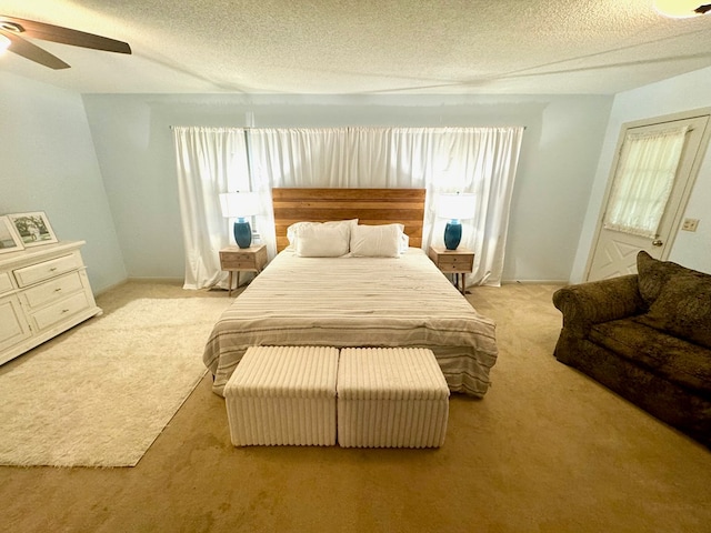 bedroom featuring multiple windows, ceiling fan, light colored carpet, and a textured ceiling