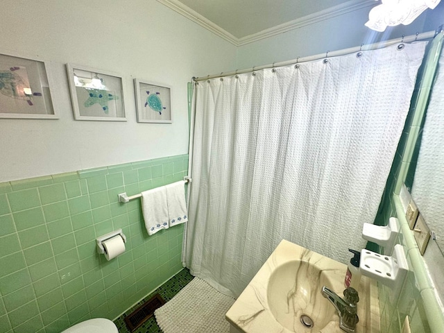 bathroom featuring a shower with curtain, sink, toilet, ornamental molding, and tile walls