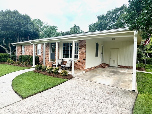 ranch-style home with a front lawn, a porch, and a carport