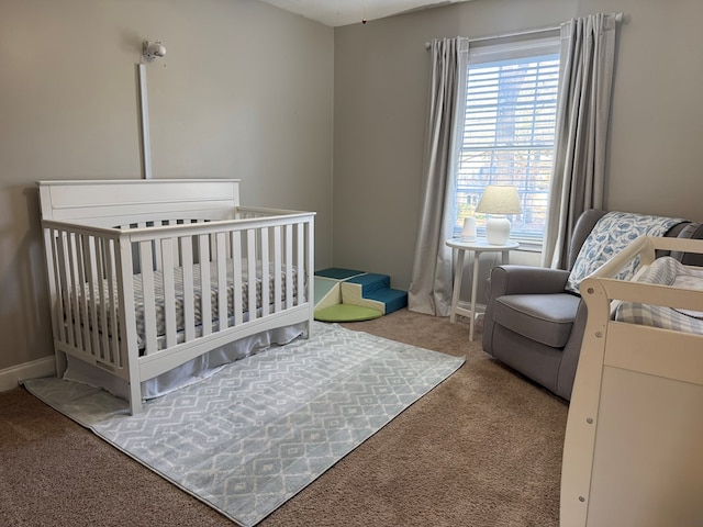 bedroom featuring a nursery area and carpet flooring