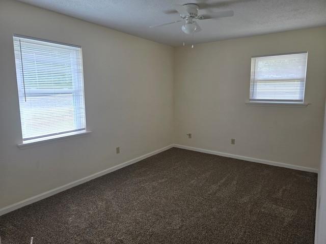 unfurnished room with baseboards, a textured ceiling, ceiling fan, and dark carpet