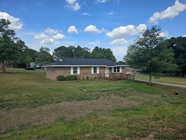 single story home with brick siding, a front yard, and a deck