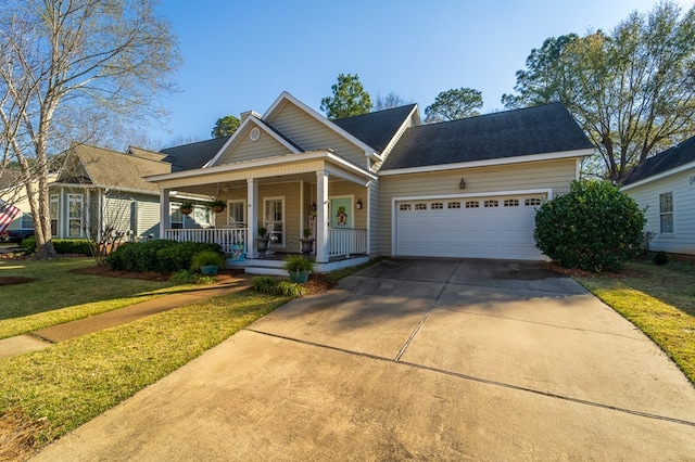 view of front of home featuring covered porch, a garage, and a front yard