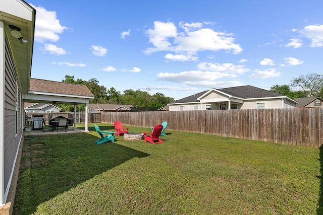view of yard with a fenced backyard, a fire pit, and a patio