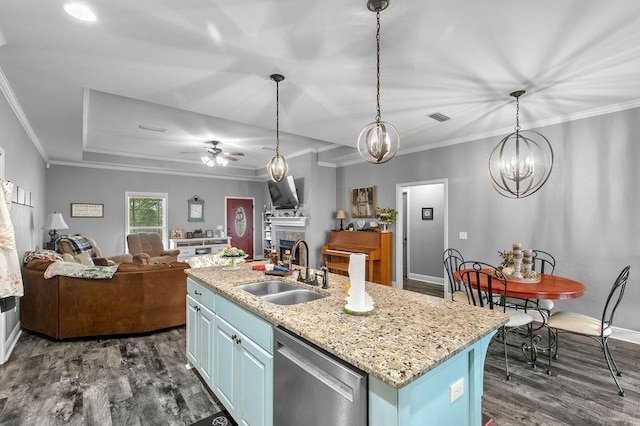 kitchen featuring blue cabinetry, open floor plan, a sink, and stainless steel dishwasher