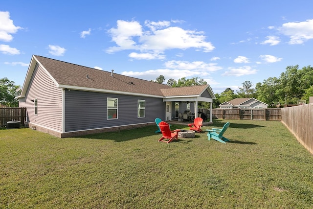 back of property featuring a fenced backyard, a fire pit, cooling unit, and a yard
