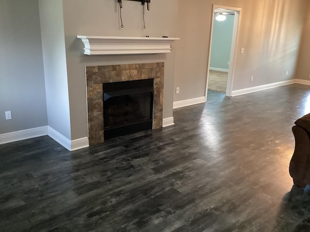 116 Jules Ln, Ashford, AL 36312 - unfurnished living room featuring a tiled fireplace, baseboards, and dark wood-type flooring