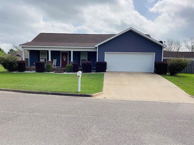 view of front facade with a front yard, covered porch, concrete driveway, a shingled roof, and a garage
