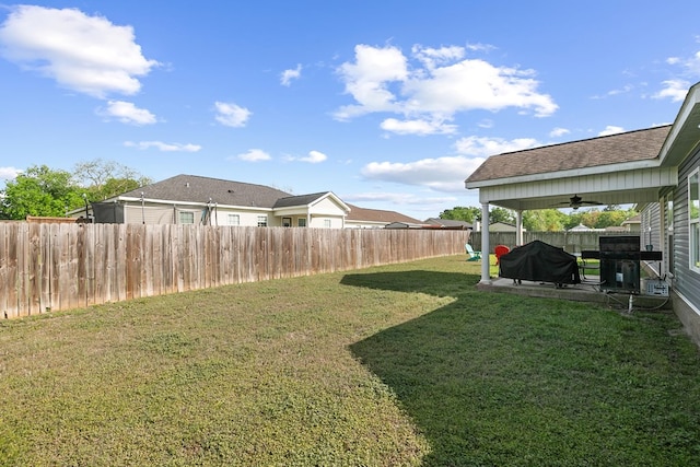 view of yard featuring a fenced backyard and a ceiling fan
