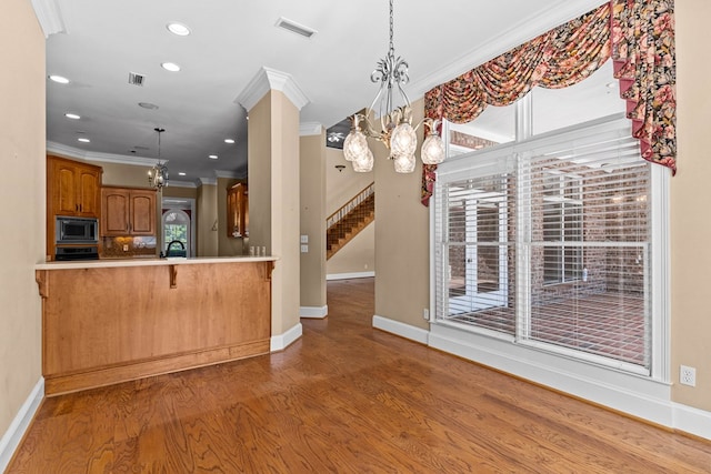 601 Edinburgh Way, Dothan, AL 36305 - kitchen featuring built in microwave, a chandelier, ornamental molding, brown cabinetry, and baseboards