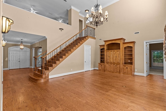 601 Edinburgh Way, Dothan, AL 36305 - unfurnished living room with a chandelier, stairway, wood finished floors, baseboards, and ornamental molding