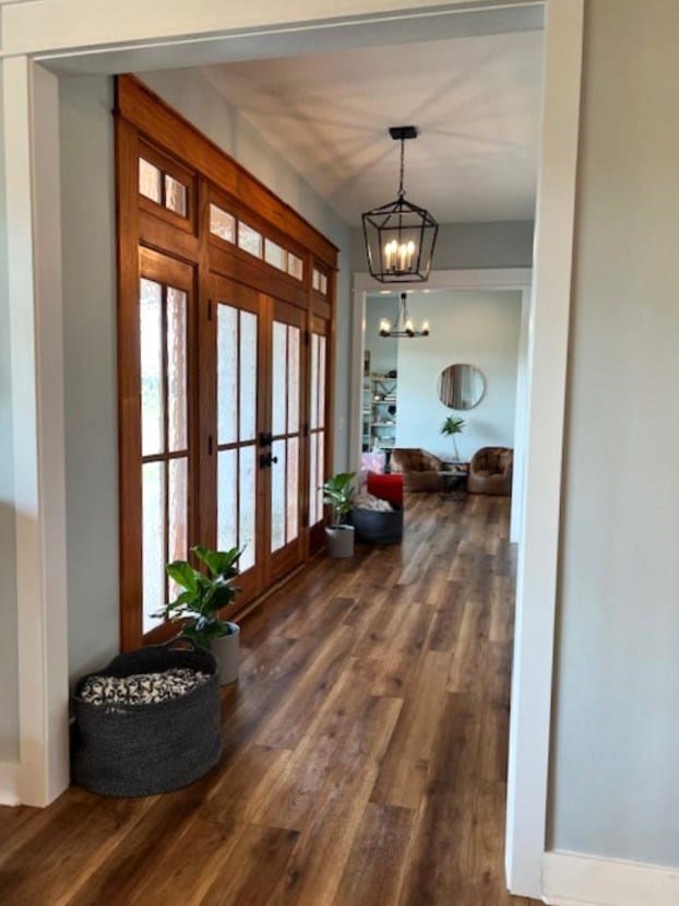 1015 Hardy Rd, Dothan, AL 36301 - hallway with french doors, dark wood-type flooring, and a chandelier