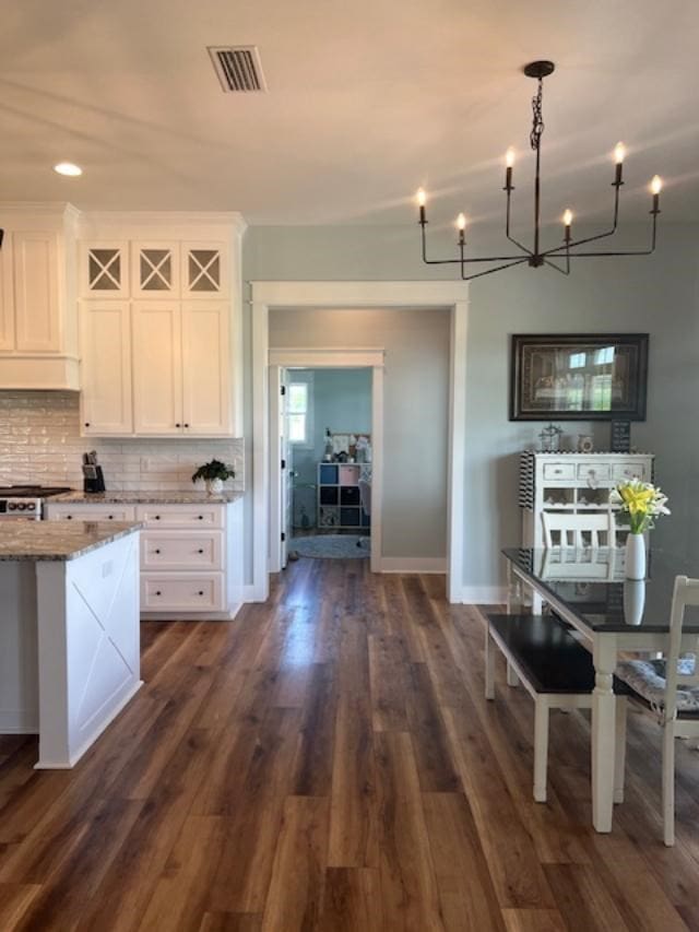 1015 Hardy Rd, Dothan, AL 36301 - kitchen featuring light stone countertops, white cabinetry, backsplash, and dark wood-style flooring