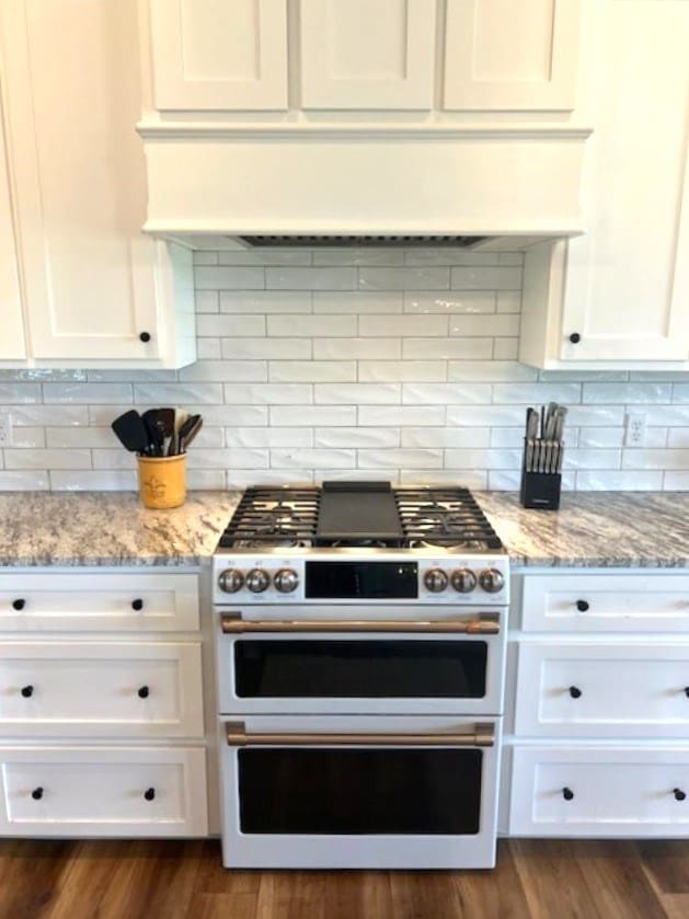 1015 Hardy Rd, Dothan, AL 36301 - kitchen with range with two ovens, white cabinetry, and light stone counters
