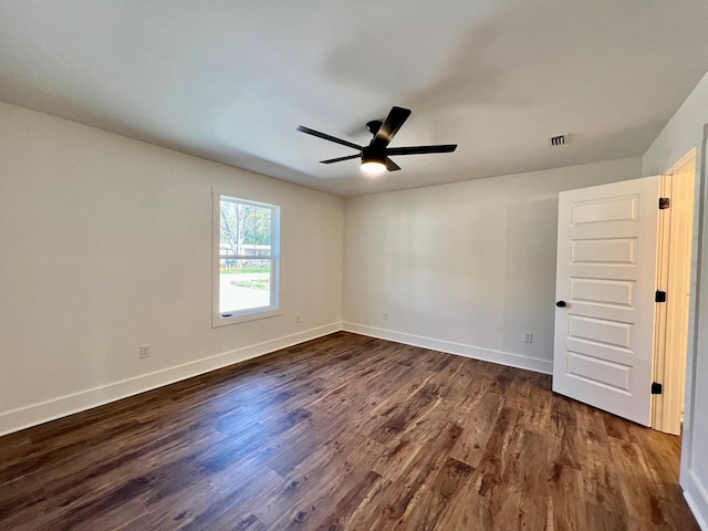 unfurnished room featuring dark wood-type flooring and ceiling fan