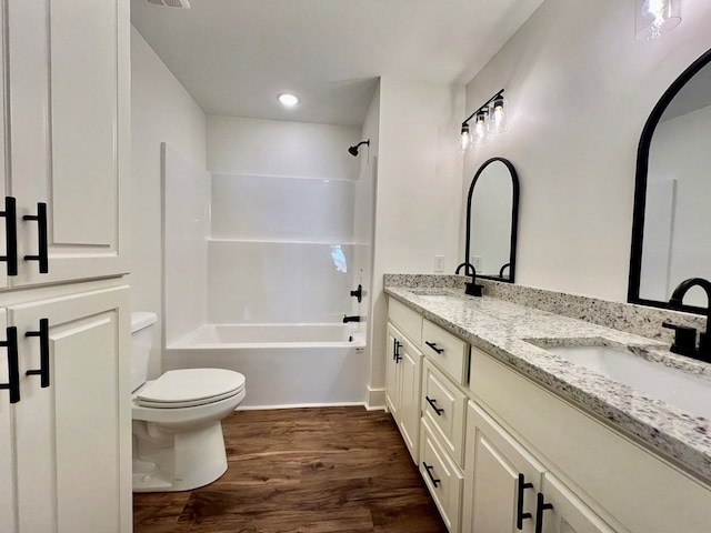 full bathroom with shower / washtub combination, toilet, hardwood / wood-style floors, and vanity