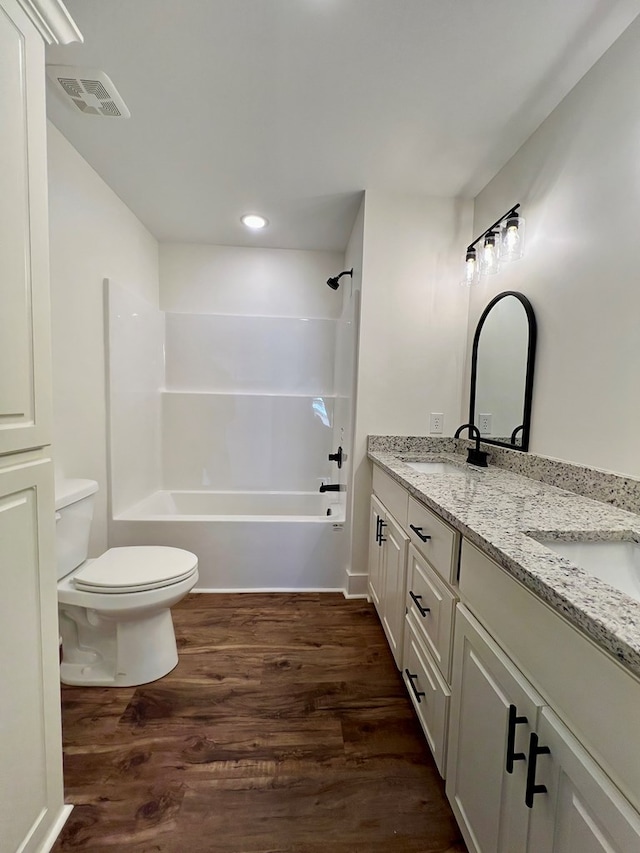 full bathroom featuring hardwood / wood-style flooring, vanity, shower / tub combination, and toilet