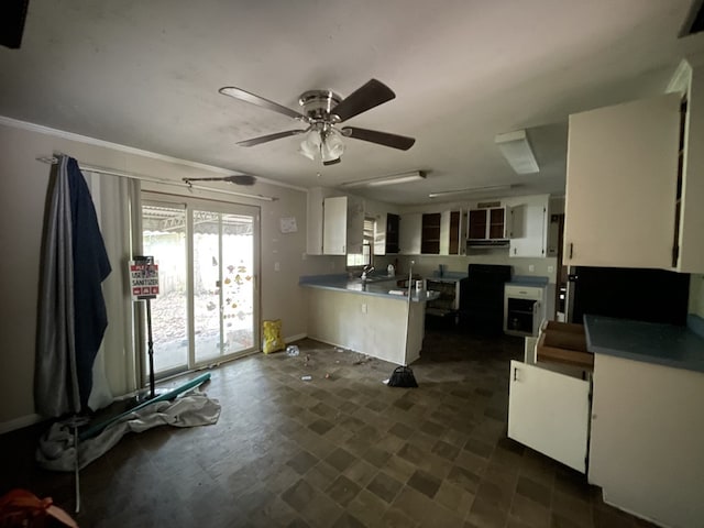 511 W Franklin St, Dothan, AL 36301 - kitchen with a peninsula, white cabinetry, ceiling fan, baseboards, and under cabinet range hood