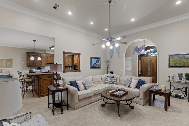 living room featuring ceiling fan, light colored carpet, and crown molding