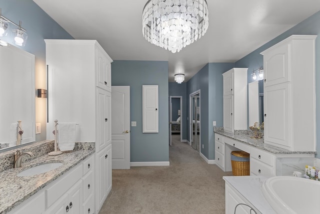 bathroom featuring vanity, a tub to relax in, and a chandelier