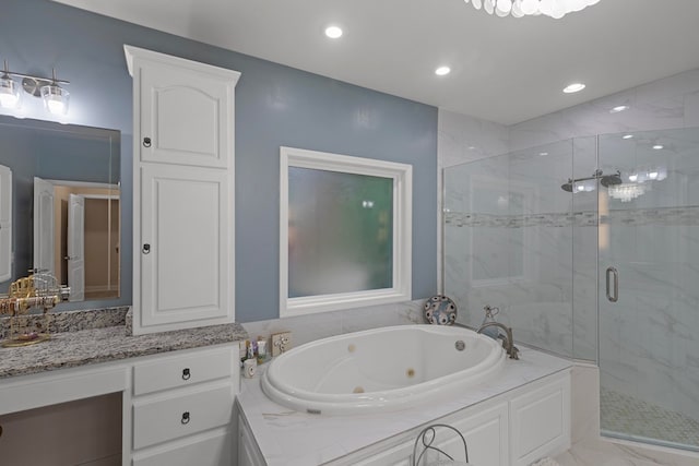 bathroom featuring vanity and independent shower and bath