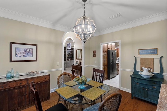 dining space featuring light hardwood / wood-style floors, crown molding, and a chandelier