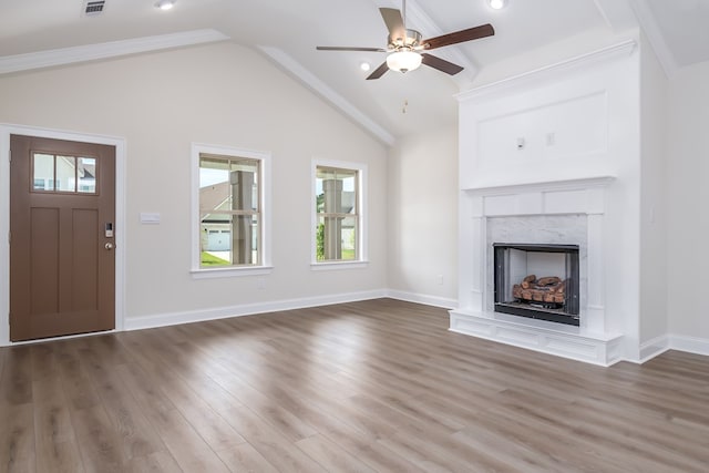 unfurnished living room featuring a ceiling fan, a wealth of natural light, a fireplace, and wood finished floors