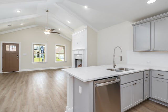 kitchen with a sink, stainless steel dishwasher, gray cabinetry, and a wealth of natural light