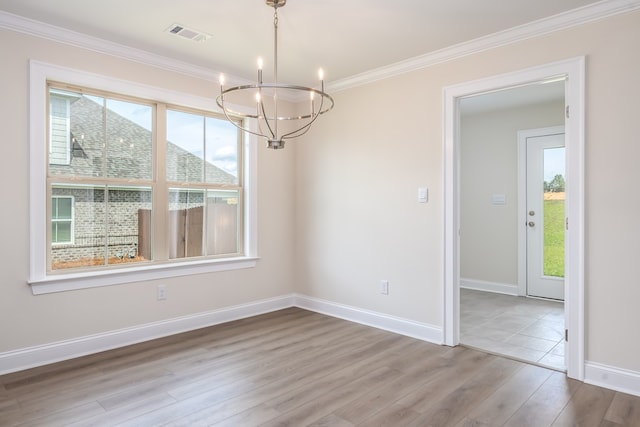 unfurnished dining area with wood finished floors, ornamental molding, visible vents, an inviting chandelier, and baseboards