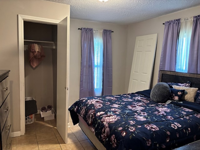 bedroom featuring light tile patterned flooring and a textured ceiling