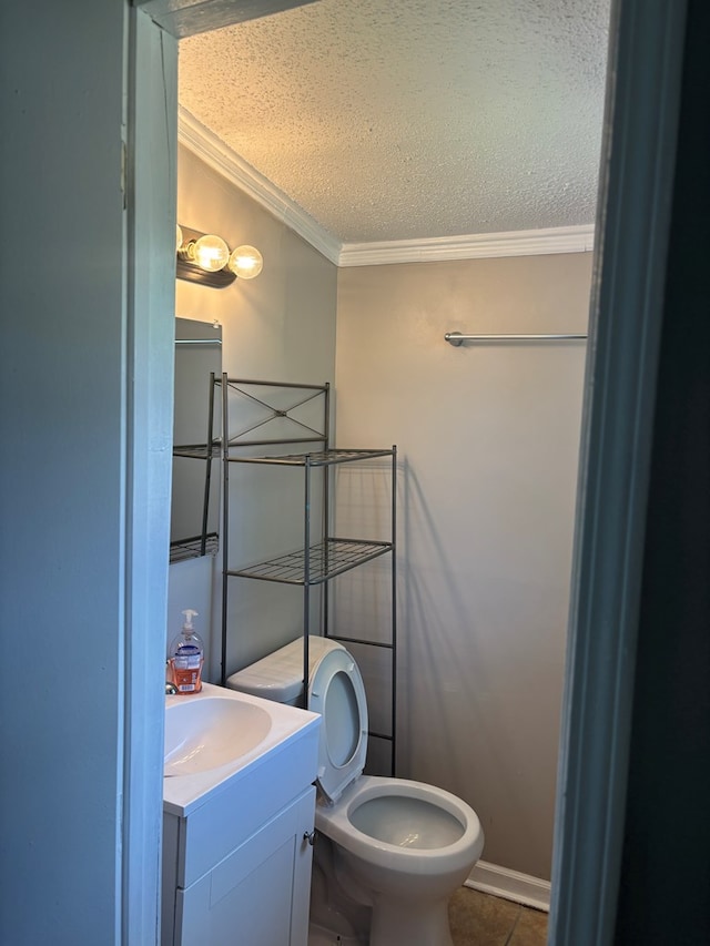 half bathroom with toilet, crown molding, a textured ceiling, tile patterned flooring, and vanity