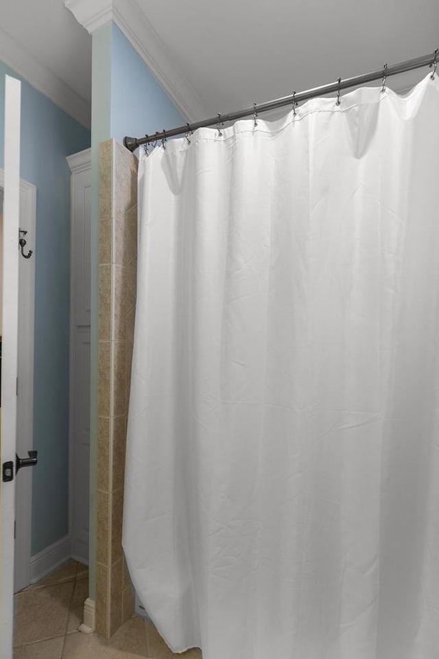 bathroom featuring tile patterned flooring, crown molding, and walk in shower