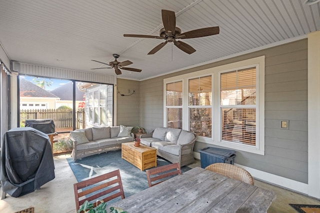 sunroom featuring ceiling fan and plenty of natural light