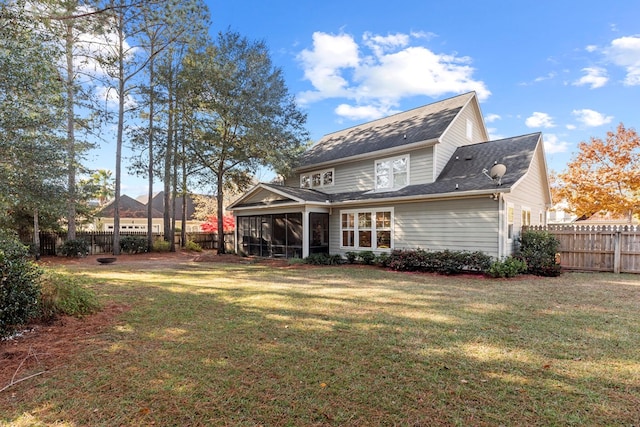 back of property with a sunroom and a lawn