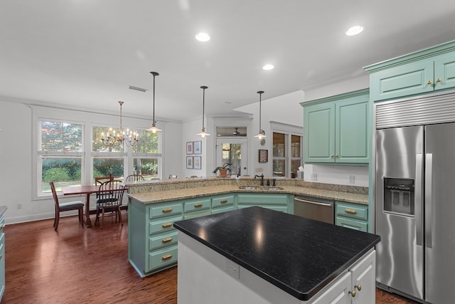 kitchen with appliances with stainless steel finishes, a center island, dark hardwood / wood-style floors, and sink