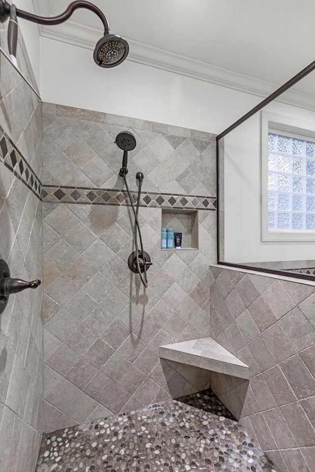 bathroom featuring tiled shower and crown molding