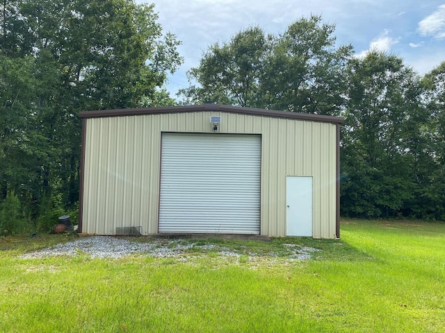 view of outdoor structure featuring a garage and a lawn