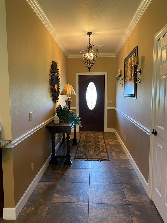 doorway to outside featuring ornamental molding and a chandelier