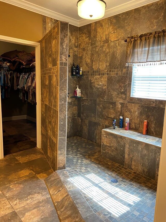 bathroom featuring ornamental molding and a tile shower