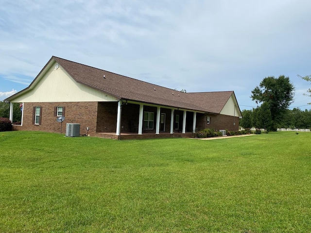 rear view of property with cooling unit and a lawn