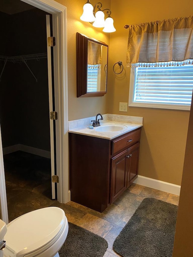 bathroom featuring vanity, a chandelier, and toilet