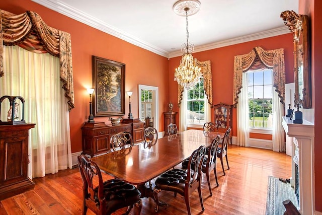 dining space with a chandelier, light hardwood / wood-style floors, and crown molding